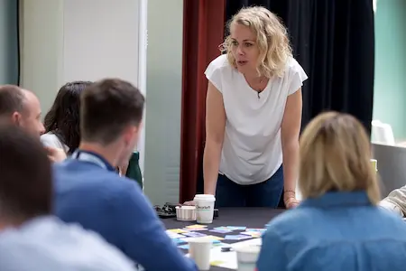 A woman smiling while she leads a workshop.