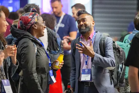 A man and a woman smiling in animated conversation.