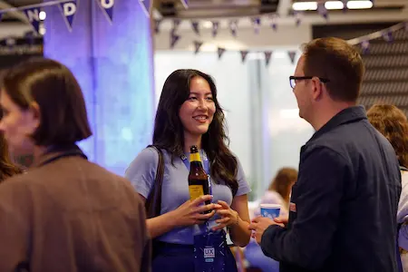 Two people smiling and chatting to one another.